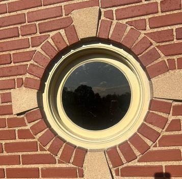 Outside view of a round, newly rehabilitated fourth-floor window.