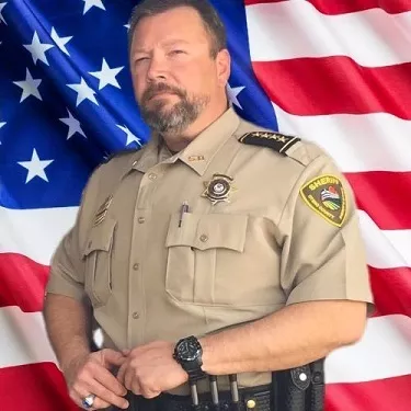 Sheriff Shawn Mobley standing in uniform in front of American flag